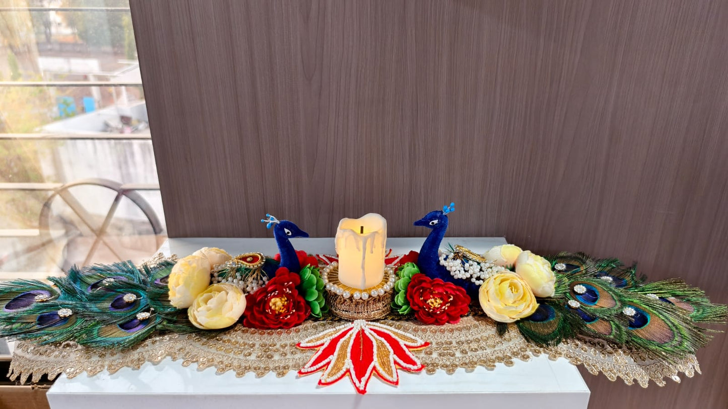 Handmade peacock candle centerpiece with blue peacock figurines, LED candle, real peacock feathers and fabric roses on gold lace runner