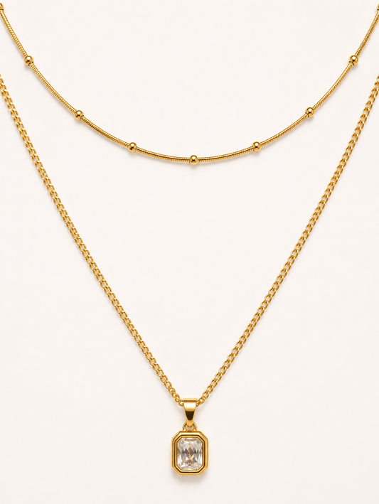 Two gold necklaces on a white background