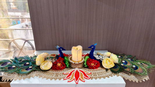 Handmade peacock candle centerpiece with blue peacock figurines, LED candle, real peacock feathers and fabric roses on gold lace runner