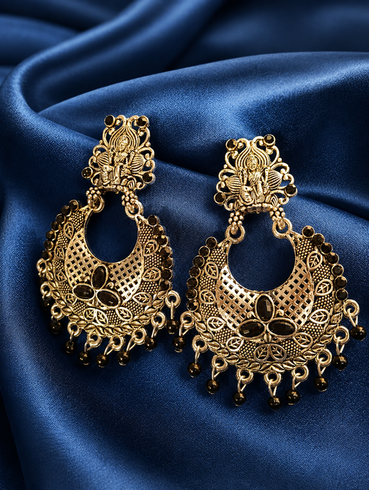 Gold earrings with Black stones on a blue satin background