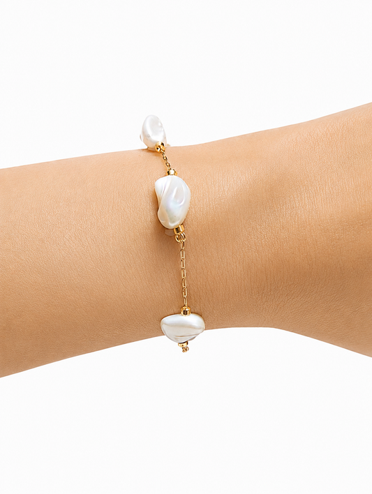 Pearl bracelet on a wrist with a white background