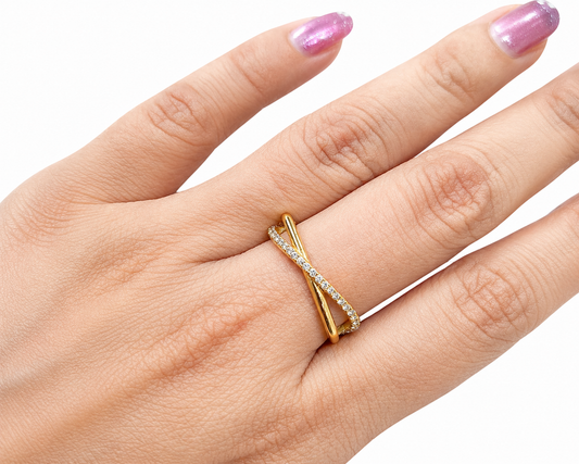 Hand wearing a gold ring with a white stone on a white background